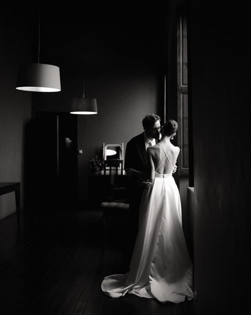 Quiet moment between newlyweds by a window at Château Rigaud, captured in moody black and white by Cleya Asulon.