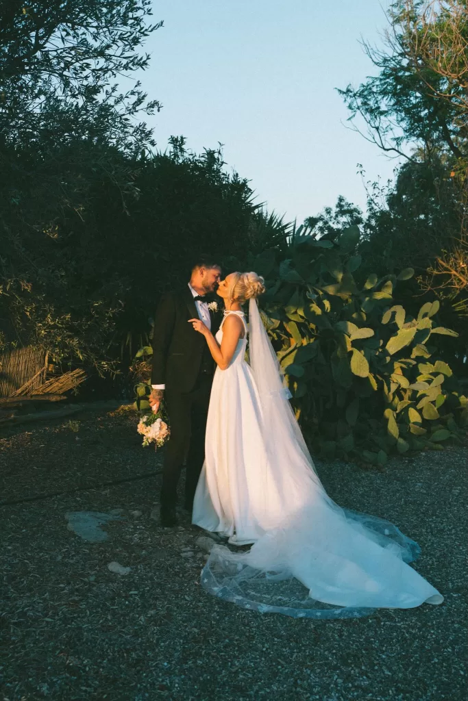 Bride and groom embrace beside cactus plants in the Cyprus countryside at Liopetro.