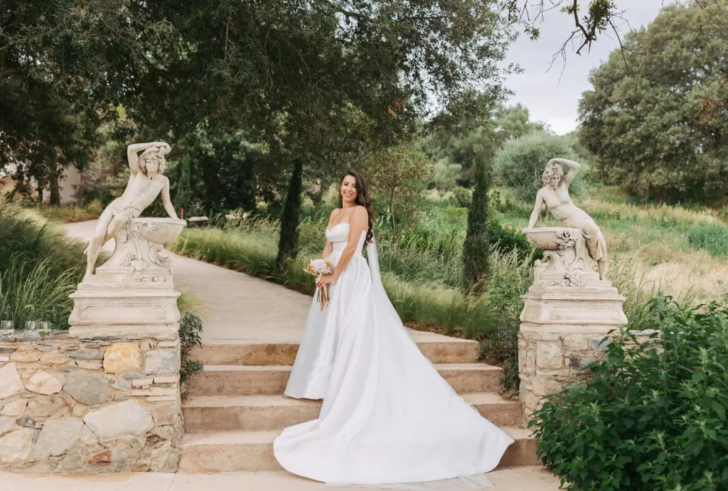 Bride and bridesmaids in white gowns holding blush-toned bouquets at Mas Torroella