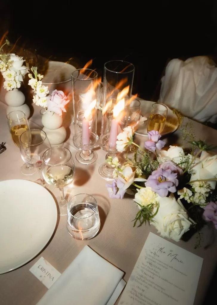 Romantic candlelit wedding dinner setup at Mas Torroella with pastel flowers and glassware