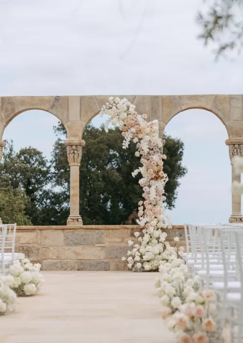 Elegant floral arch with soft pastel roses at Mas Torroella outdoor ceremony