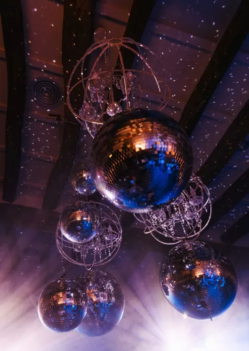 Close-up of chandelier-style disco balls casting reflections across the ceiling at Mas Torroella’s stylish reception space
