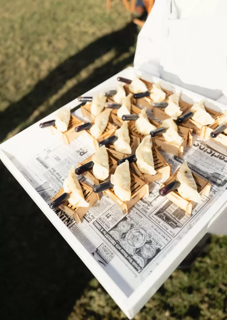 Elegant wedding canapés of handmade dumplings served in bamboo trays at Mas Torroella.