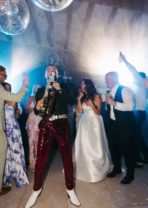 Saxophonist electrifies the dance floor at Mas Torroella while the bride and groom celebrate among their guests.