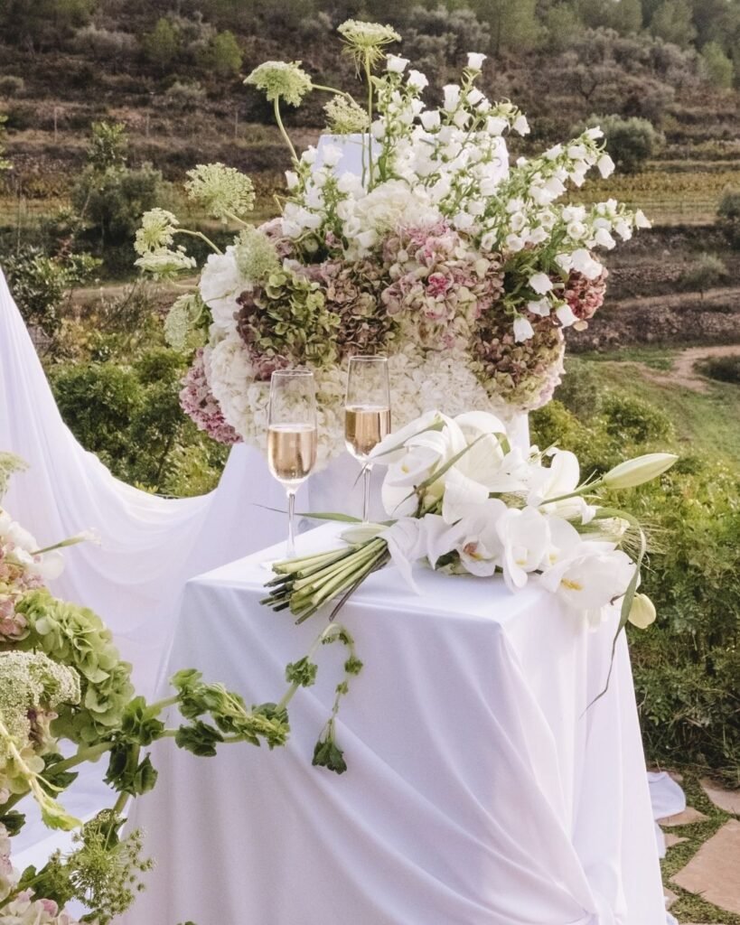 Champagne flutes and delicate floral arrangements create a sophisticated setting at Masia Cabellut wedding.