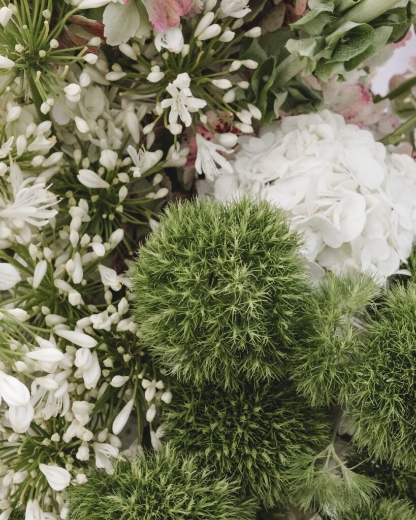 Close-up of fresh, textured wedding flowers showcasing whites and greens at Masia Cabellut, evoking natural elegance.