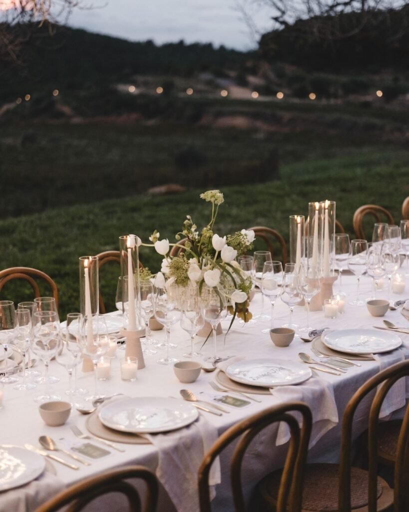 Elegant tablescape at Masia Cabellut with white tulips, wild florals and soft candlelight against the landscape.