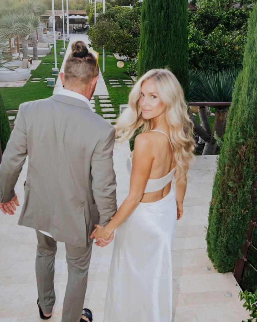 Bride and groom arriving hand-in-hand at Six Senses Ibiza, surrounded by modern Mediterranean gardens.