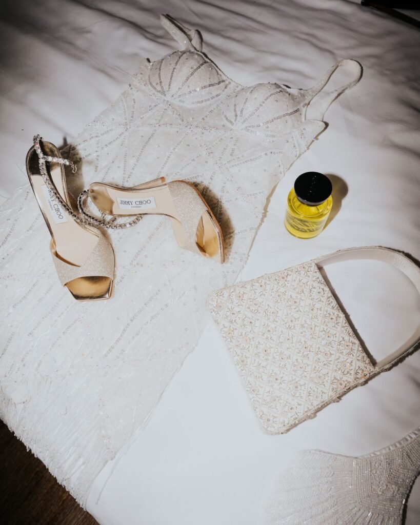Bridal outfit laid out at Six Senses Ibiza, featuring a sequinned gown, glitter heels and perfume in natural light.