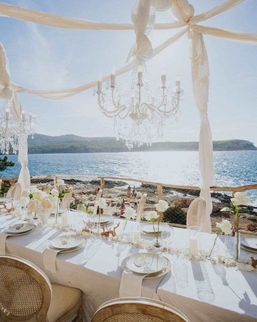 Crystal chandeliers and romantic tablescape overlooking the sea at Six Senses Ibiza.