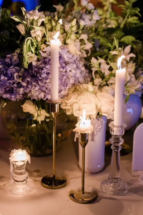 Romantic candlelit table decor with white roses and lilac hydrangeas at Uzutrakio Dvaras wedding.