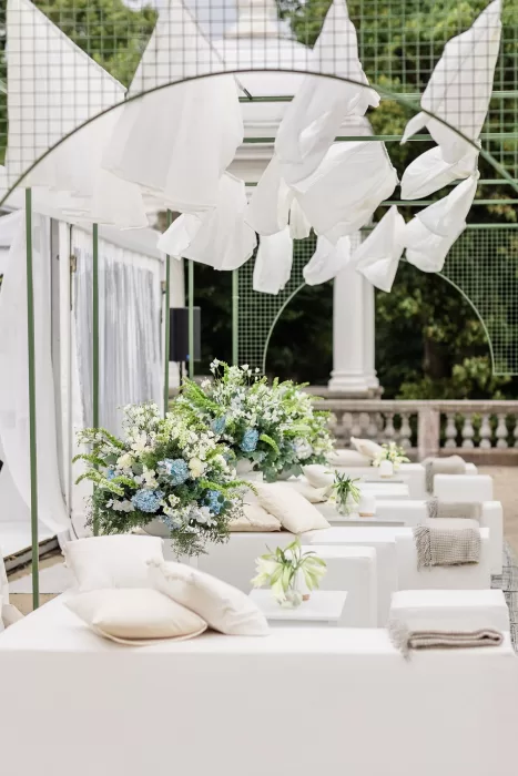 Stylish outdoor lounge setup with white sofas and lush florals at Uzutrakio Dvaras wedding.