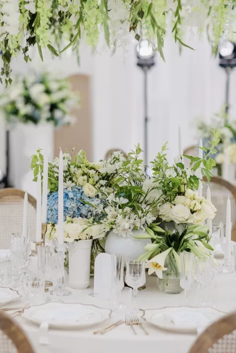 Romantic wedding reception table with lush white and blue flowers at Uzutrakio Dvaras.
