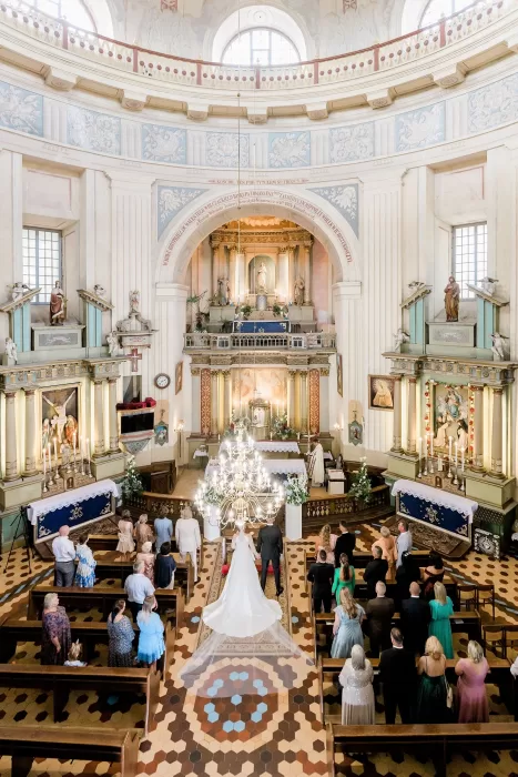 Romantic wedding ceremony inside an ornate church near Uzutrakio Dvaras.