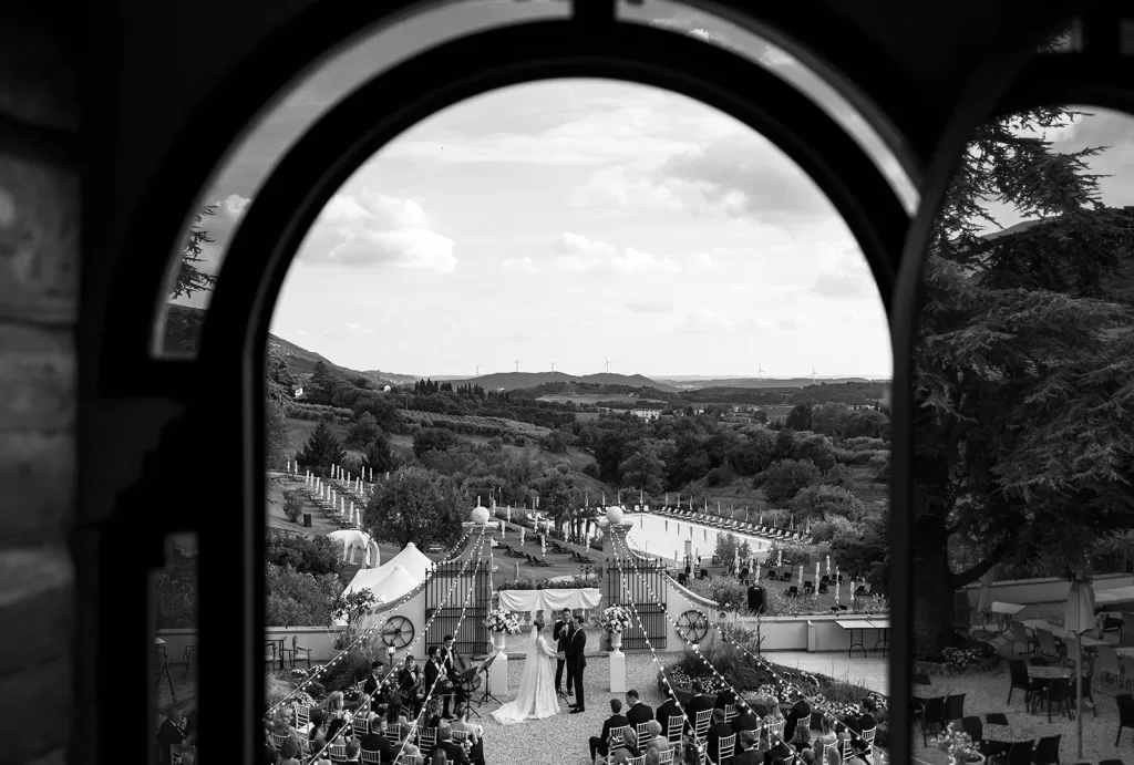 Aerial view of the wedding ceremony at Villa Cariolla, framed by a large arched window.
