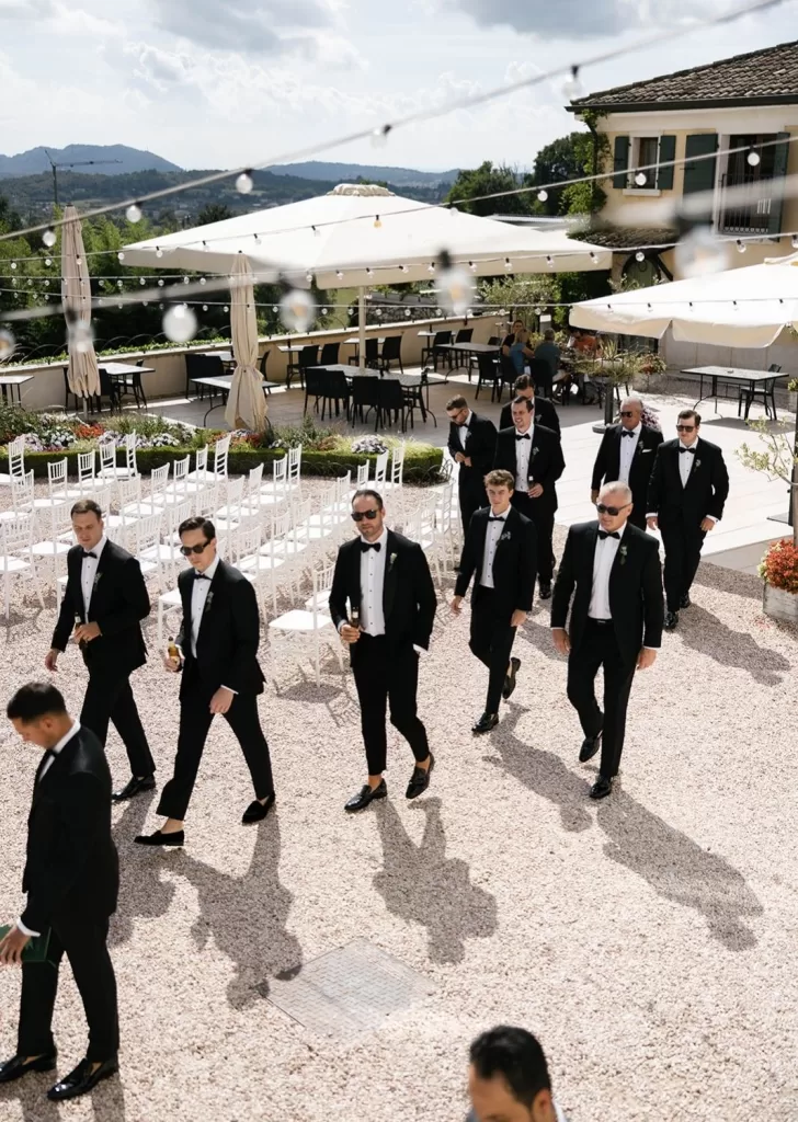 Groomsmen in black tie walking across the courtyard at Villa Cariolla, moments before the wedding ceremony.