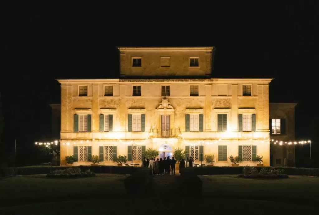 The facade of Villa di Geggiano glows under the evening sky, setting the perfect wedding backdrop.