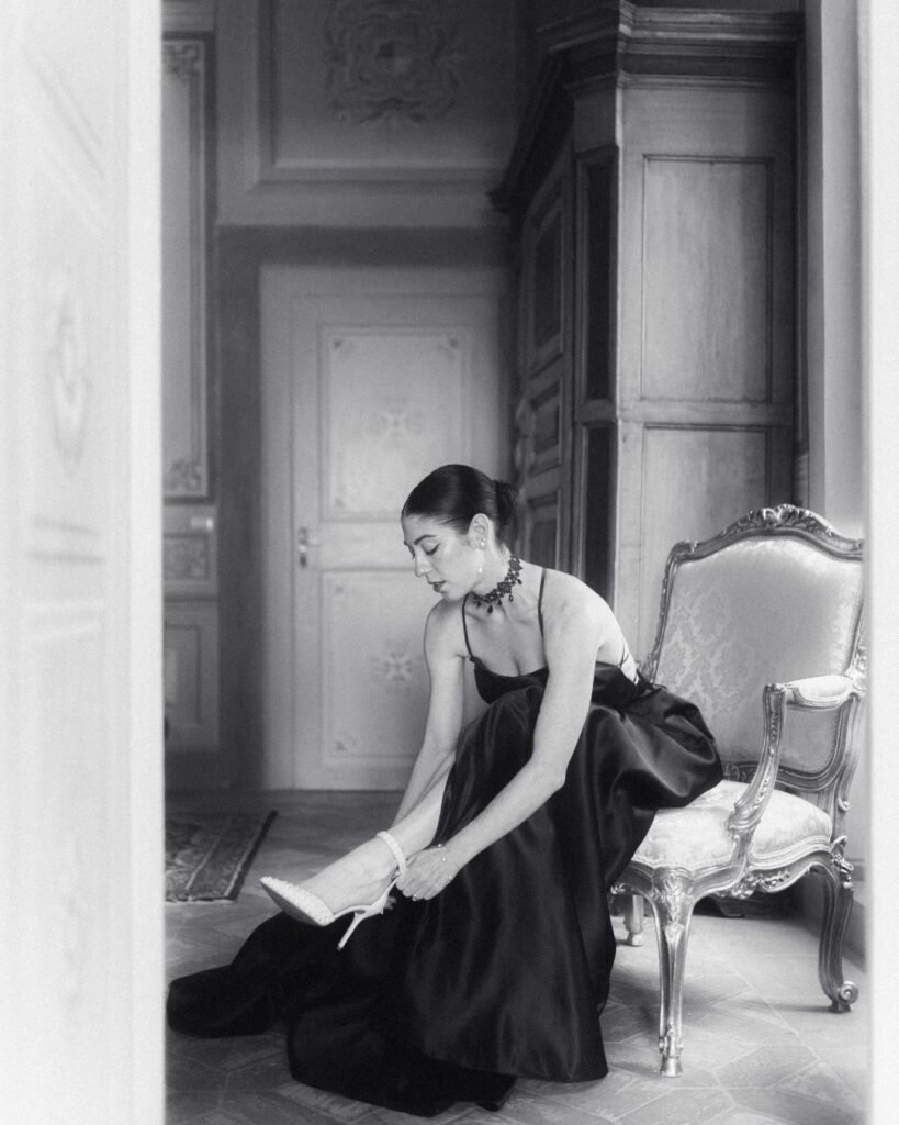Bride fastening her heels in a luxurious black gown inside Villa Ivana’s ornate bridal suite.