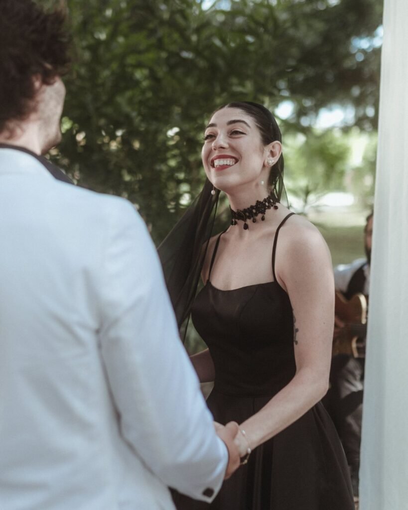 Bride and groom exchanging joyful smiles during their wedding ceremony under the trees at Villa Ivana.