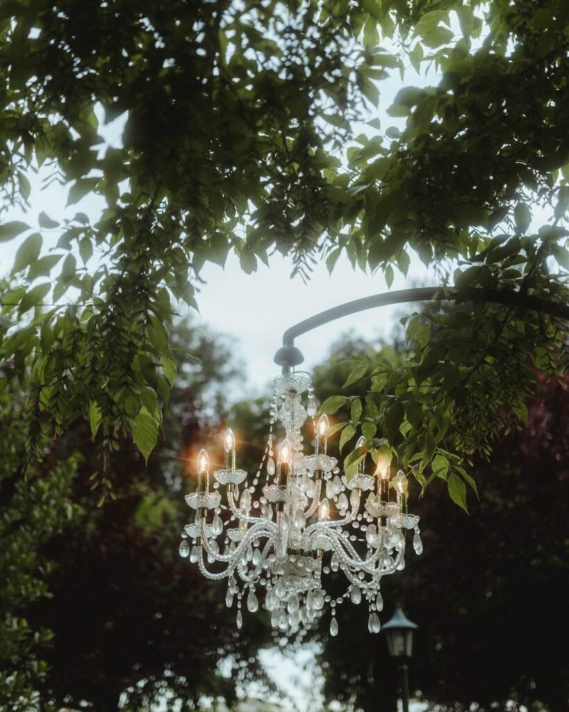 Crystal chandelier hanging among the trees for an enchanting outdoor wedding dinner at Villa Ivana.