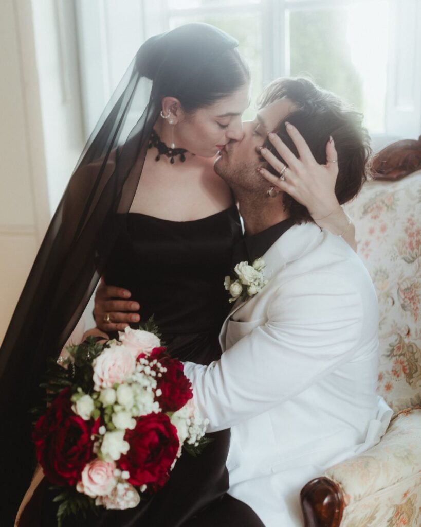 Groom dips his bride for a romantic kiss in the softly lit hallway of Villa Ivana, bouquet in hand.