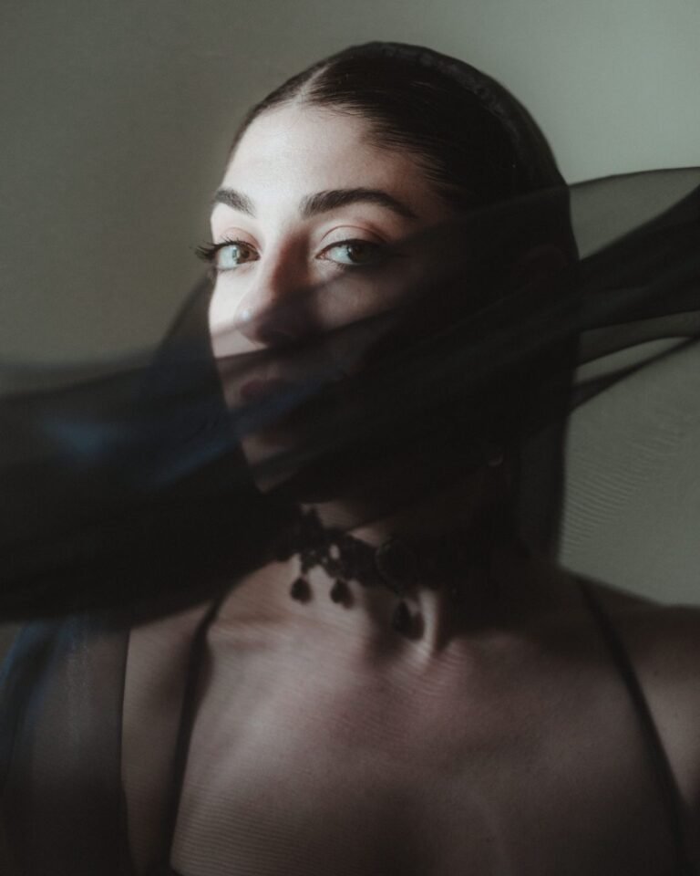 Striking bridal portrait with sheer black veil partially covering the bride’s face, captured in soft light at Villa Ivana.