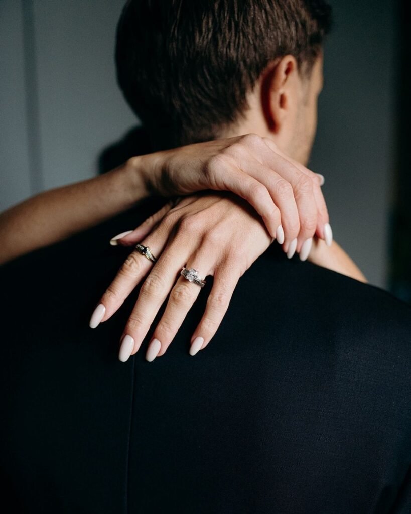 Close-up of the couple’s wedding rings as the bride embraces the groom, shot at Château Rigaud.