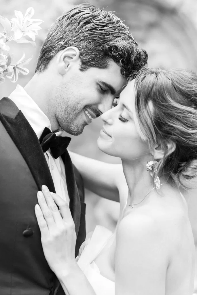 Black and white close-up portrait of the bride and groom laughing together against the timeless stone walls of Bastide du Roy, highlighting genuine emotion.