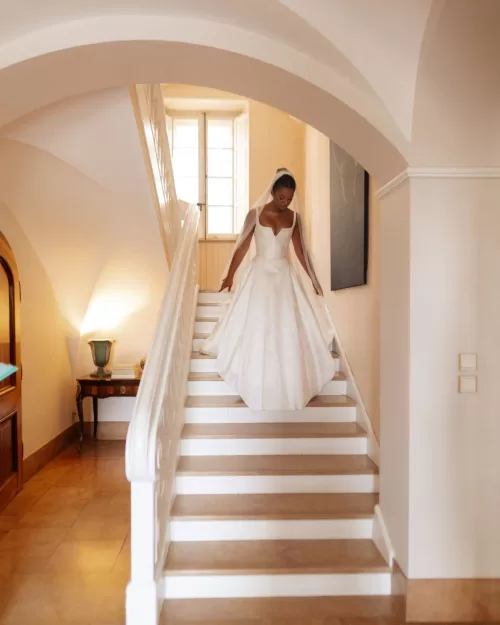 Bride elegantly descending the stone stairs of Bastide du Roy, her gown flowing beautifully as she steps towards the ceremony.