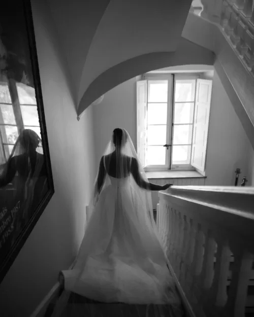 Bride gracefully descending the stone stairs of Bastide du Roy, her wedding gown flowing behind her.