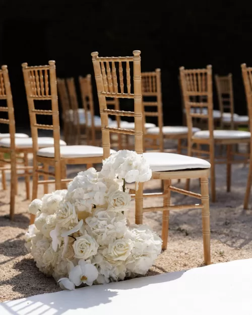 Soft pastel flowers adorning ceremony aisle chairs at Bastide du Roy, enhancing the wedding ambiance.