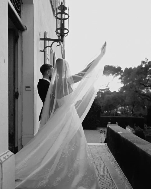 Newlyweds wave to their wedding guests from the grand balcony of Bastide du Roy, celebrating their love.
