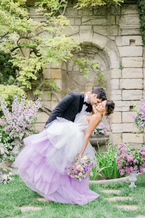 Bride and groom sharing a dramatic dip and kiss beneath the ancient trees at Bastide du Roy, capturing raw joy and timeless romance.