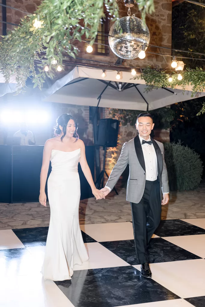 Bride and groom share a joyful first dance under a disco ball at Borgo Sant Ambrogio.