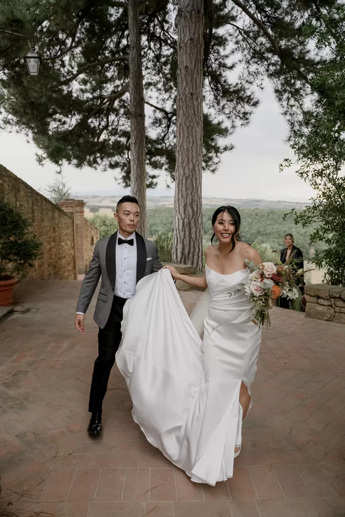 Bride and groom laugh and hold hands after the ceremony at Borgo Sant'Ambrogio