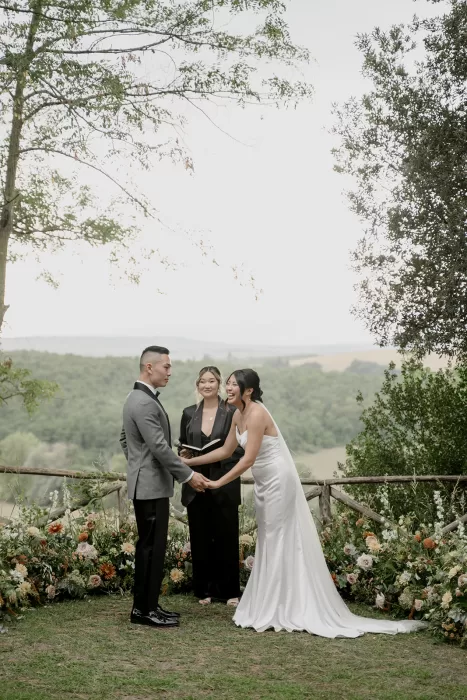 Joyful moment as the bride laughs during vows at a heartfelt countryside ceremony at Borgo Sant'Ambrogio.