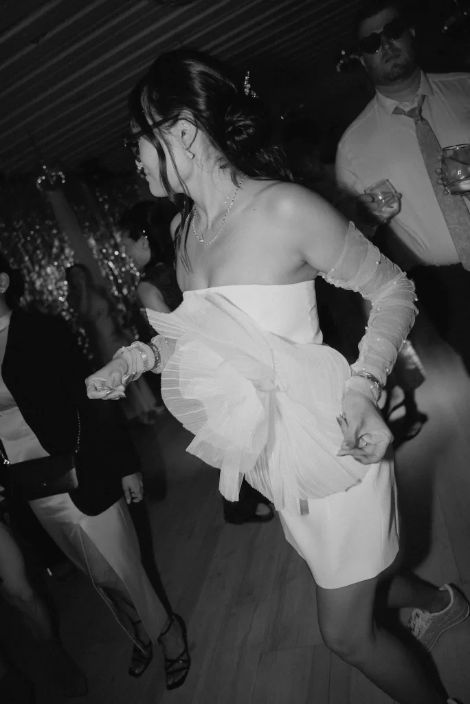 Bride changes into a modern white mini dress with sculptural detail for the Ca Na Xica after-party.
