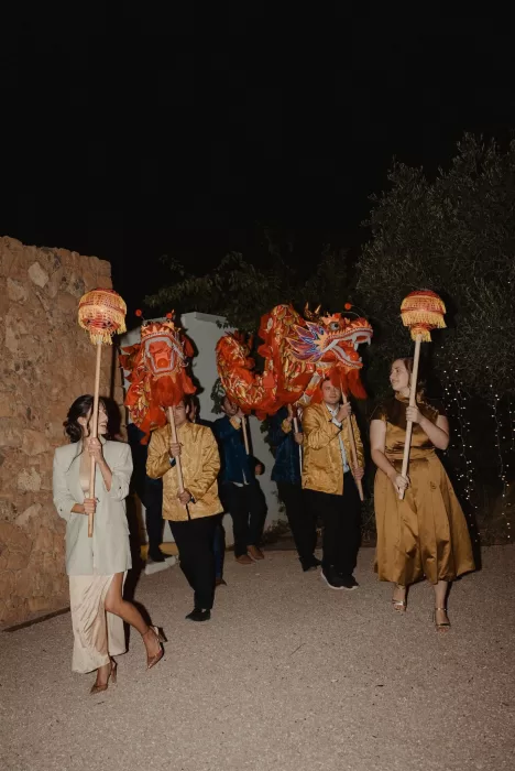Wedding guests welcome a vibrant Chinese dragon dance procession at Ca Na Xica.