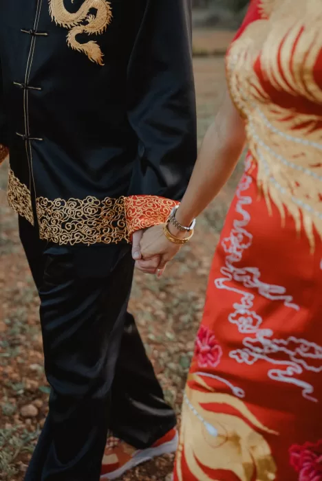 Close-up of the couple holding hands, showcasing intricate embroidery of their traditional outfits at Ca Na Xica.