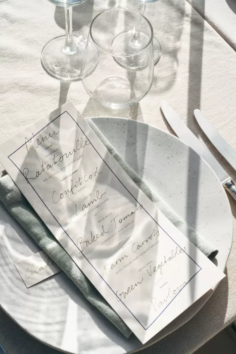 Close-up of modern wedding menu styled with neutral linens at Casa Sacoto