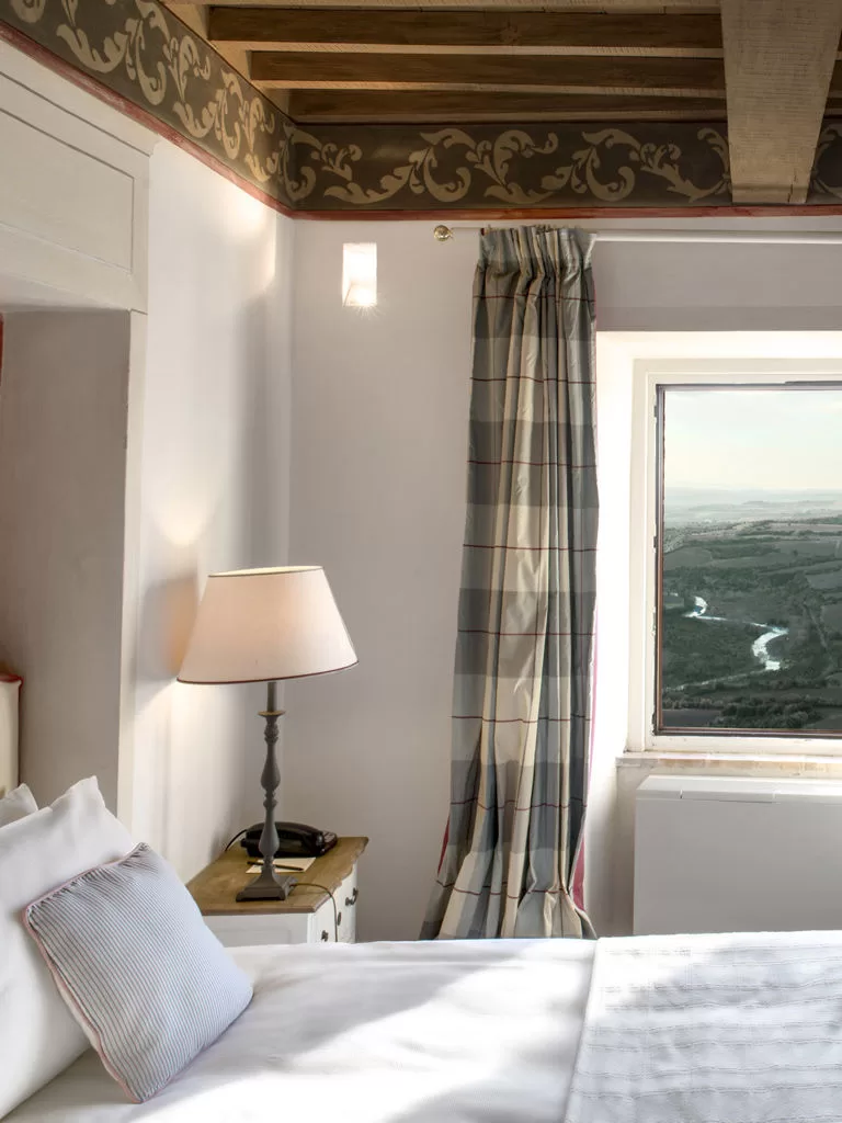 View from a Castello di Velona bedroom window onto vineyards and distant hills.