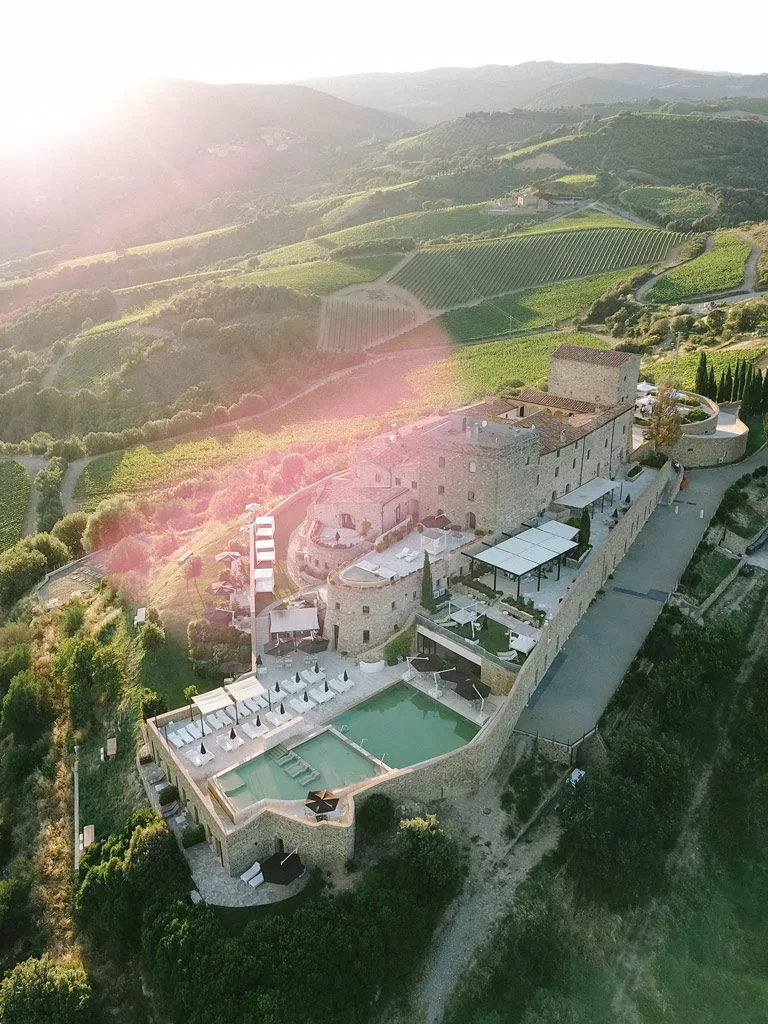 Sunset over Castello di Velona, casting golden light across the Tuscan valley.