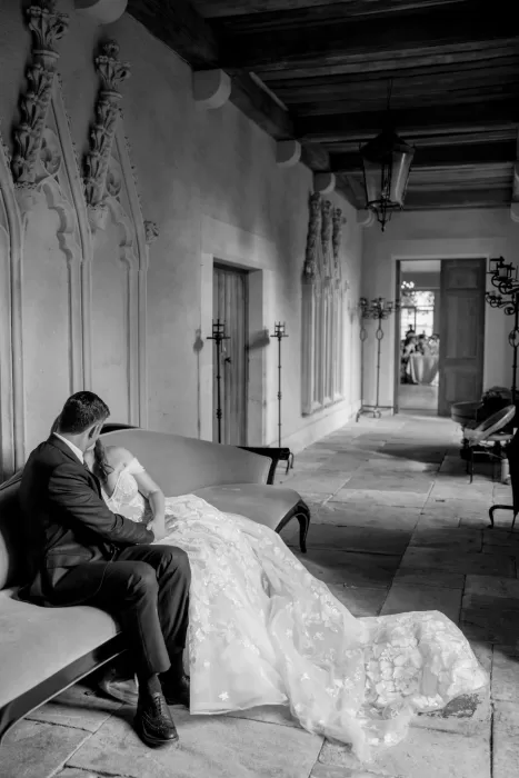 The bride walks gracefully through Euridge Manor’s arched corridor, her long train trailing behind her in soft light.