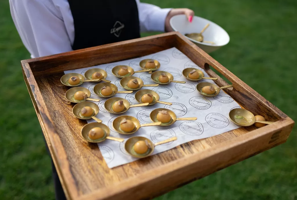 Gourmet wedding canapés served on gold spoons by L’Empordà catering at Mas Torroella