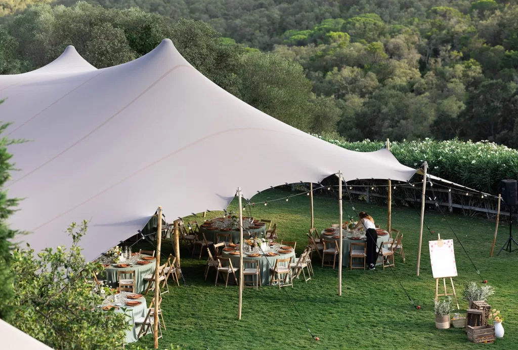 Garden reception setup under a stretch tent, nestled in the lush grounds of Mas Torroella.