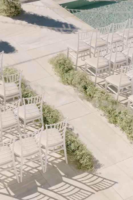 Minimalist ceremony aisle at Rocabella Santorini adorned with soft white florals and ocean views