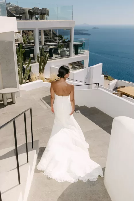 Bride walks through serene white corridors of Rocabella Santorini on her way to the altar