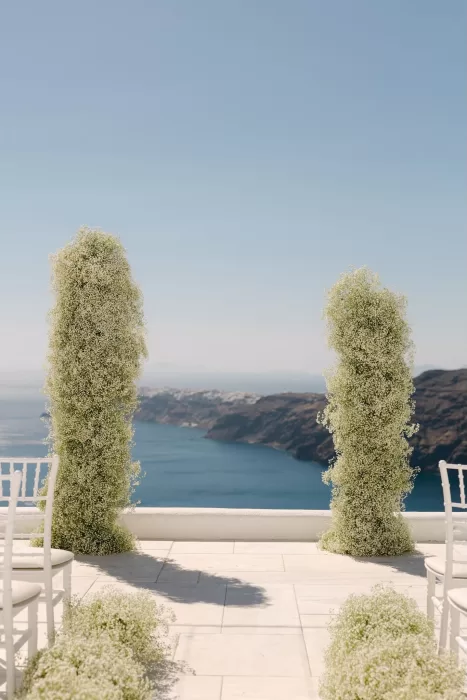 Ceremony floral pillars frame breathtaking caldera views at Rocabella Santorini