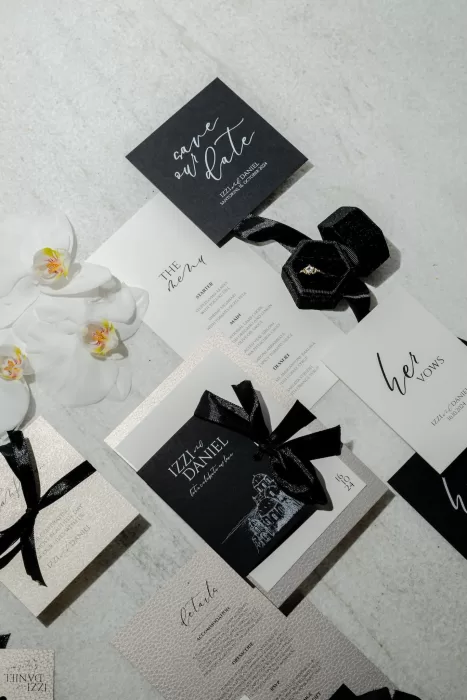 Elegant black and ivory wedding stationery with velvet ring box and orchids for a wedding at Rocabella Santorini.