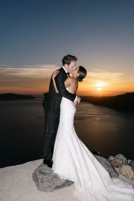 Golden hour kiss overlooking the cliffs at Rocabella Santorini